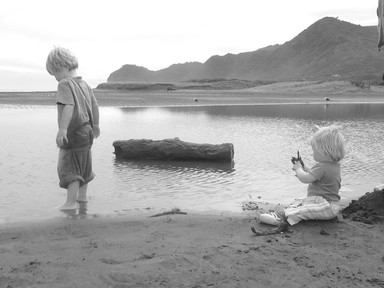  Photo of a Brother and Sister at piha on overcast but warm day.